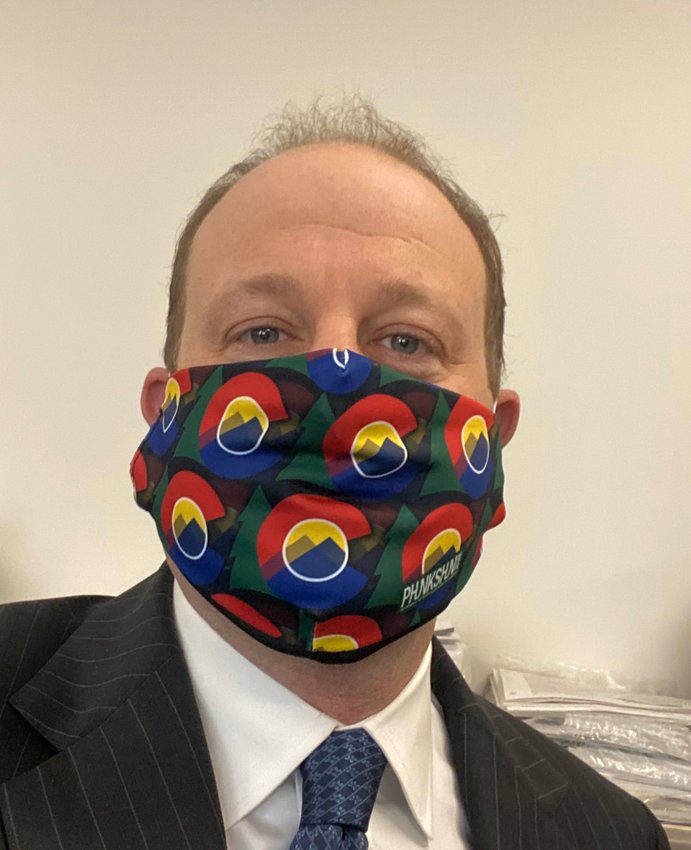 Gov. Jared Polis wears a Colorado-themed mask. The governor on April 3 announced guidance that Coloradans should wear cloth masks or scarves when they leave home for essential activities such as grocery shopping. But medical masks should be reserved for workers who need them, Polis said.